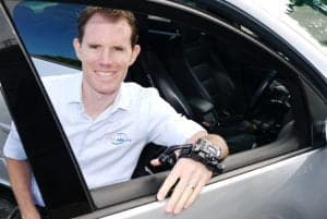 Man in wheelchair leaning on open car door