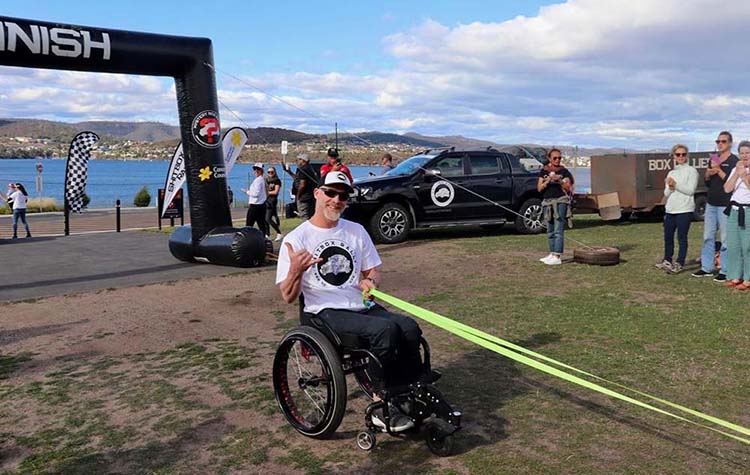 Chris Astill Crossing the Finish Line Pulled Behind His Car